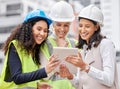 Plans are digital these days. three attractive female engineers using a tablet while working on a construction site.