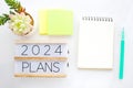 2024 plans on wood box and blank notebook paper on white marble background, business new year aim to success Royalty Free Stock Photo