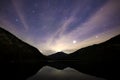 plansee at starry night with mountain silhouette and reflection