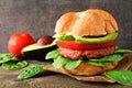 Plant based meatless burger with avocado, tomato and spinach against a dark background Royalty Free Stock Photo