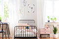 Bed in white kid`s room interior with posters and chair at desk. Real photo Royalty Free Stock Photo