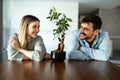 Plant care. Nature protection concept. Smiling environmentally friendly couple with houseplants.