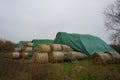 A stack of hay collected in rolls under an awning on the field. 12529 Schoenefeld, Germany