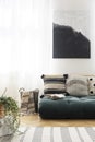 Futon with patterned cushions in natural living room interior with poster. Real photo Royalty Free Stock Photo