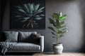 Plant next to grey corner sofa in african living room interior with poster and pouf. Real photo Royalty Free Stock Photo