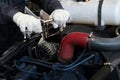 The technician tightens the bolt with a socket wrench. Closeup of male hands tightening a nut on a tractor engine. Automotive