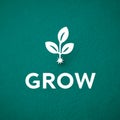 Plant sprouting with 'grow' text on green textured background. Royalty Free Stock Photo