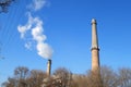 Plant tubes with gray smoke on blue sky, chemical plant towers of nuclear power plant against the blue sky