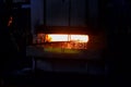 The plant worker hardens the metal in a huge red-hot furnace in the production workshop of the plant