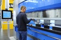 At the plant. Worker holding the metal sheet working with the CNC hydraulic press brake machine, the board of computer numerical Royalty Free Stock Photo