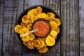 Plantain chips served with Colombian traditional hogao on top of a wooden table Royalty Free Stock Photo