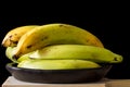 Plantain or Green Banana Musa x paradisiaca in a ceramic traditional dish on dark background