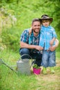 Planting flowers. Growing plants. Take care of plants. Boy and father in nature with watering can. Spring garden. Dad Royalty Free Stock Photo