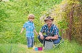 Planting flowers. Growing plants. Take care of plants. Boy and father in nature with watering can. Gardening tools. Dad Royalty Free Stock Photo