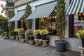 Plants and floral decorations near the building with different street furniture and flower pots.