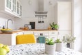 Table in stylish white kitchen interior, real photo