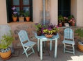 Plants in pots on window sills and old table chairs in informal display. Royalty Free Stock Photo