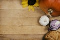 Plants and vegetables on wooden table. Pumpkin with sunflower and bread with other vegetables and food on wooden board. Vegan food