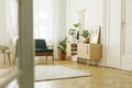 Plants on wooden cupboard with poster in white loft interior wit