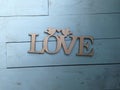 Plaque carved in wood with an inscription love on a blue background Royalty Free Stock Photo