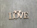 Plaque carved in wood with an inscription love on a gray background Royalty Free Stock Photo