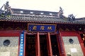 The plaque of the City God Temple has golden letters and borders, black tiles, a dragon head carved on the roof, a red-lacquered