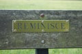 A plaque saying `reminisce` on a park bench Royalty Free Stock Photo