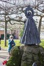 An old woman prays before the sculpture of the Virgen del Puerto located in the Coronation Park