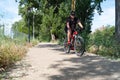 Portrait of a happy smiling man dressed in cycling clothes, helmet and sunglasses riding a bicycle