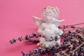 Plaster angel figurine with a heart with lavender branches on a pink background, side view, space for text Royalty Free Stock Photo