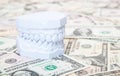 Plaster cast of teeth on dollar notes