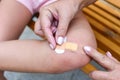 A plaster on a child`s leg. the child bruised his legs. girl`s knee injury. medical first aid outdoor