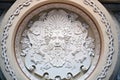 A fragment of a coffered ceiling in a historic building with a stucco decoration in the form of a Dionysus mask.