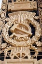 Plaster panel depicting a hammer sickle and golden wheat ears on a clear sunny day.