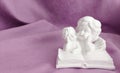Plaster statuette of two angels reading a book Royalty Free Stock Photo