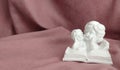 Plaster statuette of two white angels reading a large book Royalty Free Stock Photo