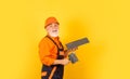 Plaster trowel spatula on yellow drywall plasterboard. Plasterer in working uniform plastering. man with spatula