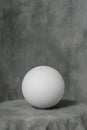 Plaster white sphere or ball, on a gray fabric artistic background. Royalty Free Stock Photo