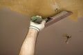 Plasterer applies plaster to the ceiling at renovation work Royalty Free Stock Photo