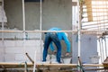 Plasterer in blue working uniform plastering the wall of house building site. hands plasterer tools. industrial worker with