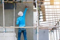 Plasterer in blue working uniform plastering the wall of house building site. hands plasterer tools. industrial worker with