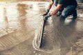 Plasterer concrete worker at floor of house construction