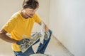 Plasterer home improvement handyman worker with putty knife working on apartment wall filling Royalty Free Stock Photo