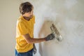 Plasterer home improvement handyman worker with putty knife working on apartment wall filling Royalty Free Stock Photo