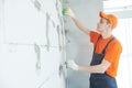 Plasterer installing screed on wall for plastering