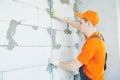 Plasterer installing screed on wall for plastering Royalty Free Stock Photo