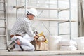 Plasterer man construction worker takes the plaster trowel from the toolbox wear gloves, hard hat and protection glasses at Royalty Free Stock Photo