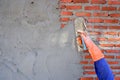 Plasterer man using wooden trowel to plastering cement on brick wall Royalty Free Stock Photo