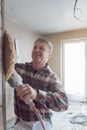 Plasterer smoothing interior wall of new homes with machine Royalty Free Stock Photo