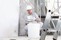 Plasterer man at work, take the mortar from the bucket to plastering the wall of interior construction site wear helmet and Royalty Free Stock Photo